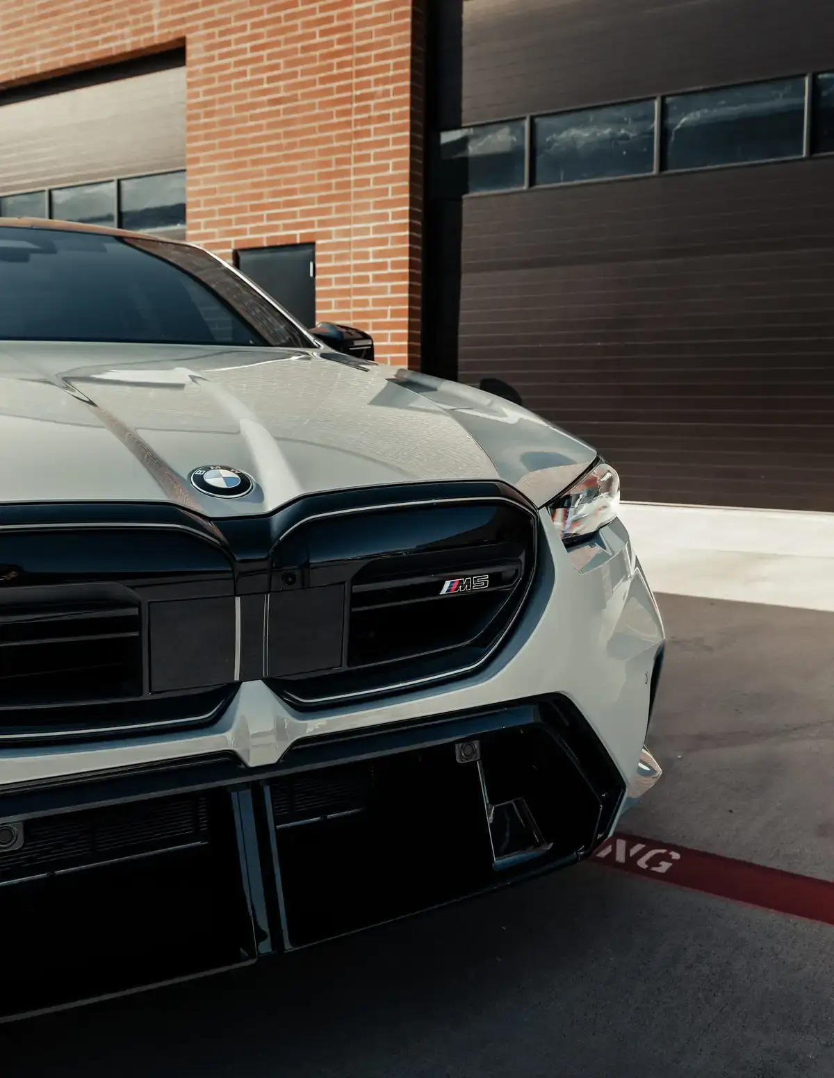 White Bmw M5 closeup front end shot. The image shows that it was completed by Paint Protection DFW, a clear bra installer in Fort Worth